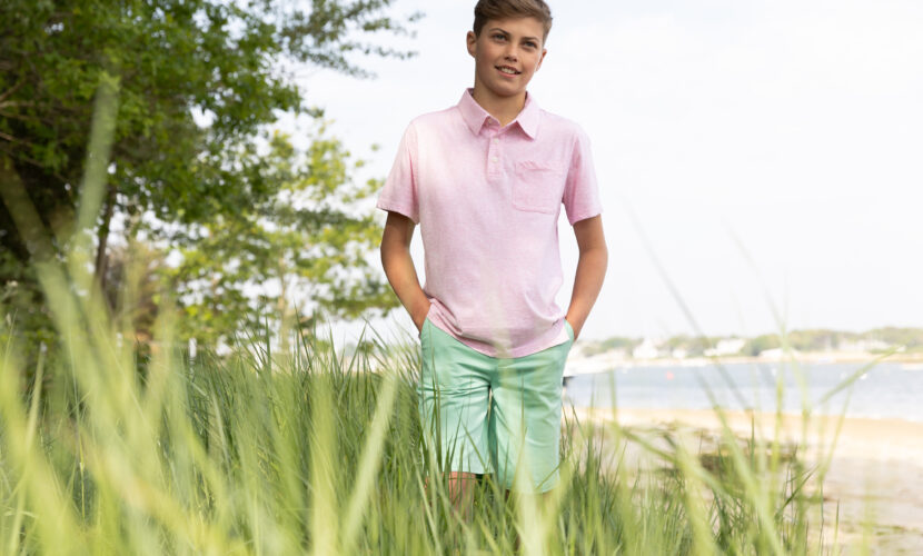 Boy wearing a polo shirt and a tee in a field, showcasing a casual spring look for boys from the new Spring collection.