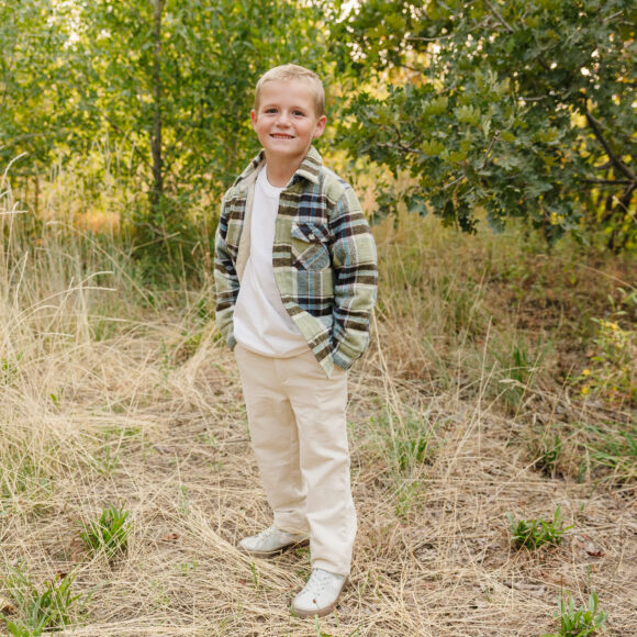 Chino-Flex Boys Dress Pants in Stone - Casual Outdoor Look Boy wearing Chino-Flex boys dress pants in stone with plaid shacket and white tee outdoors